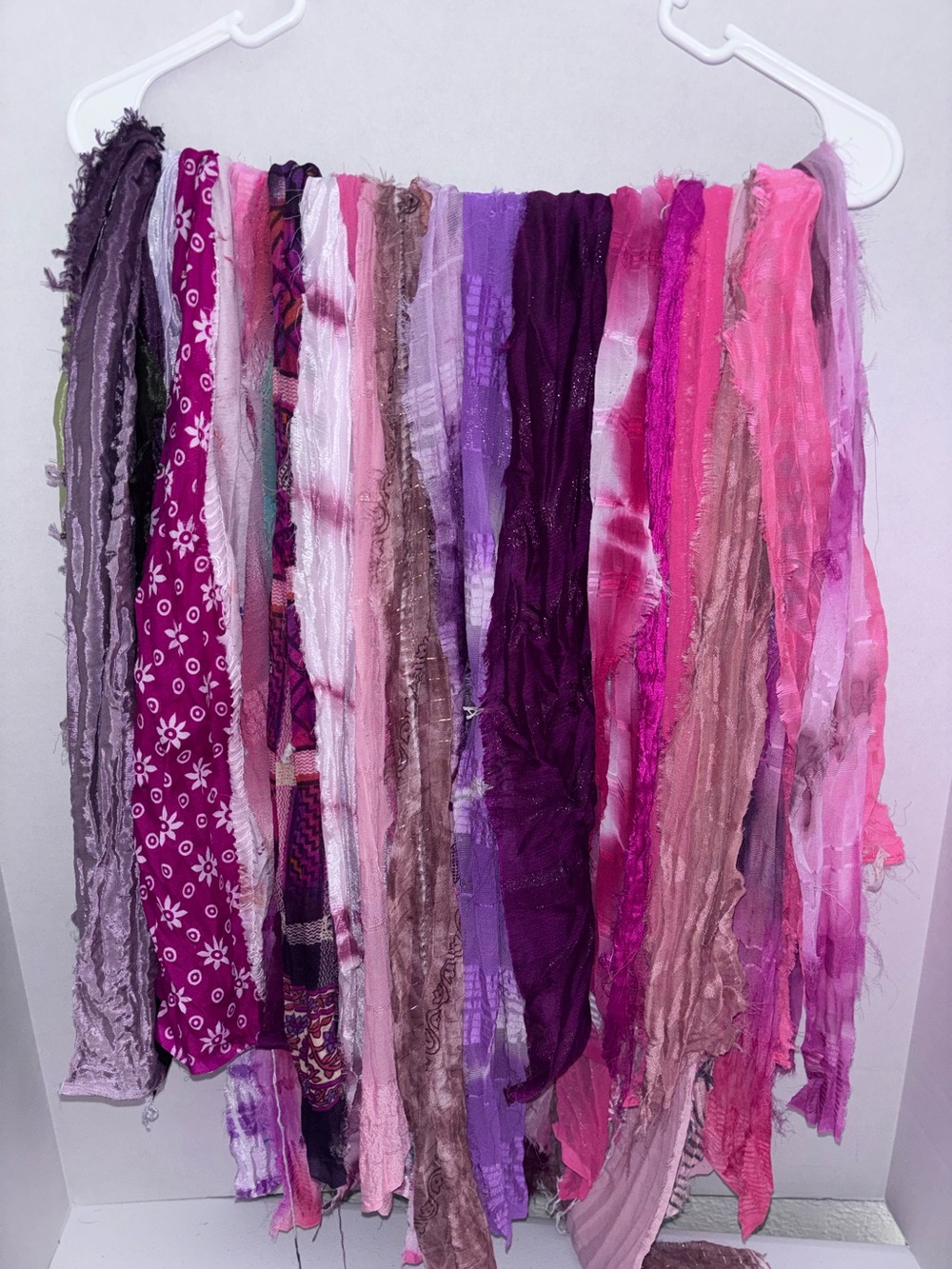 Vibrant sari silk fabric strands in purple and burgundy and pink hues.